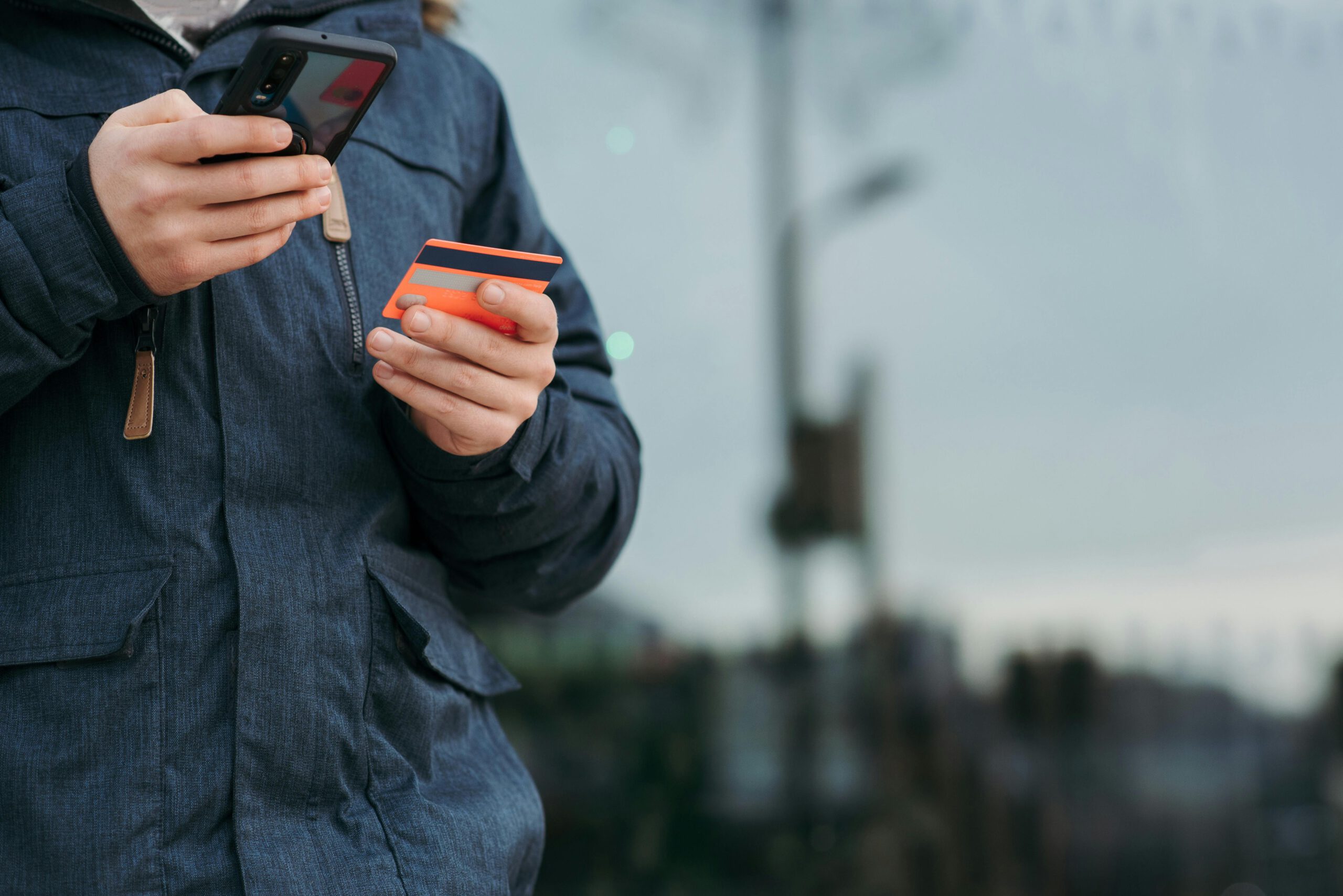 Person In Der Schwarzen Jacke, Die Schwarzes Smartphone Hält