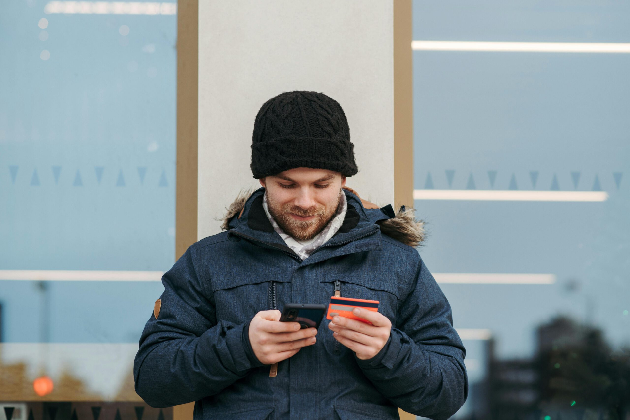 Mann In Schwarzer Strickmütze Und Schwarzer Jacke, Die Schwarzes Smartphone Halten